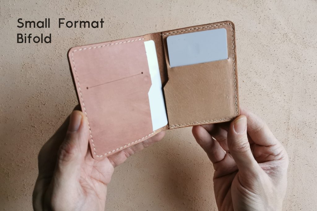 lerif designs hands holding small format bifold wallet with cards peeking out