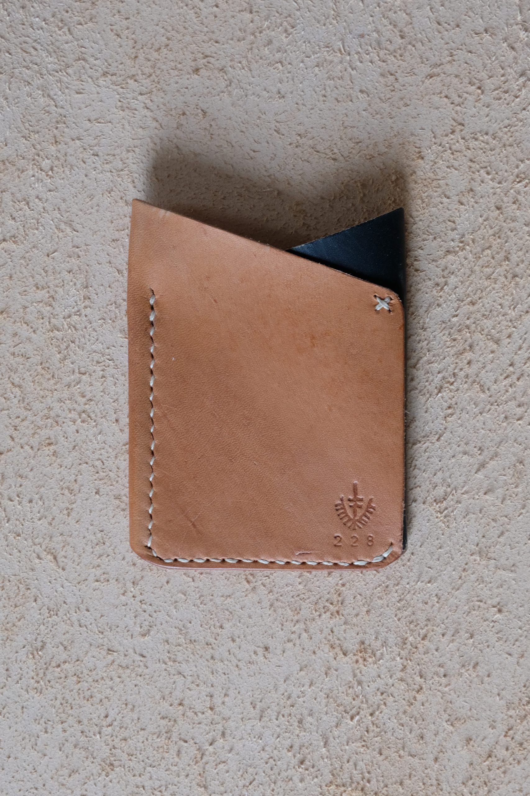 lerif designs leather fox ears cardholder in natural and indigo on beige backgroun