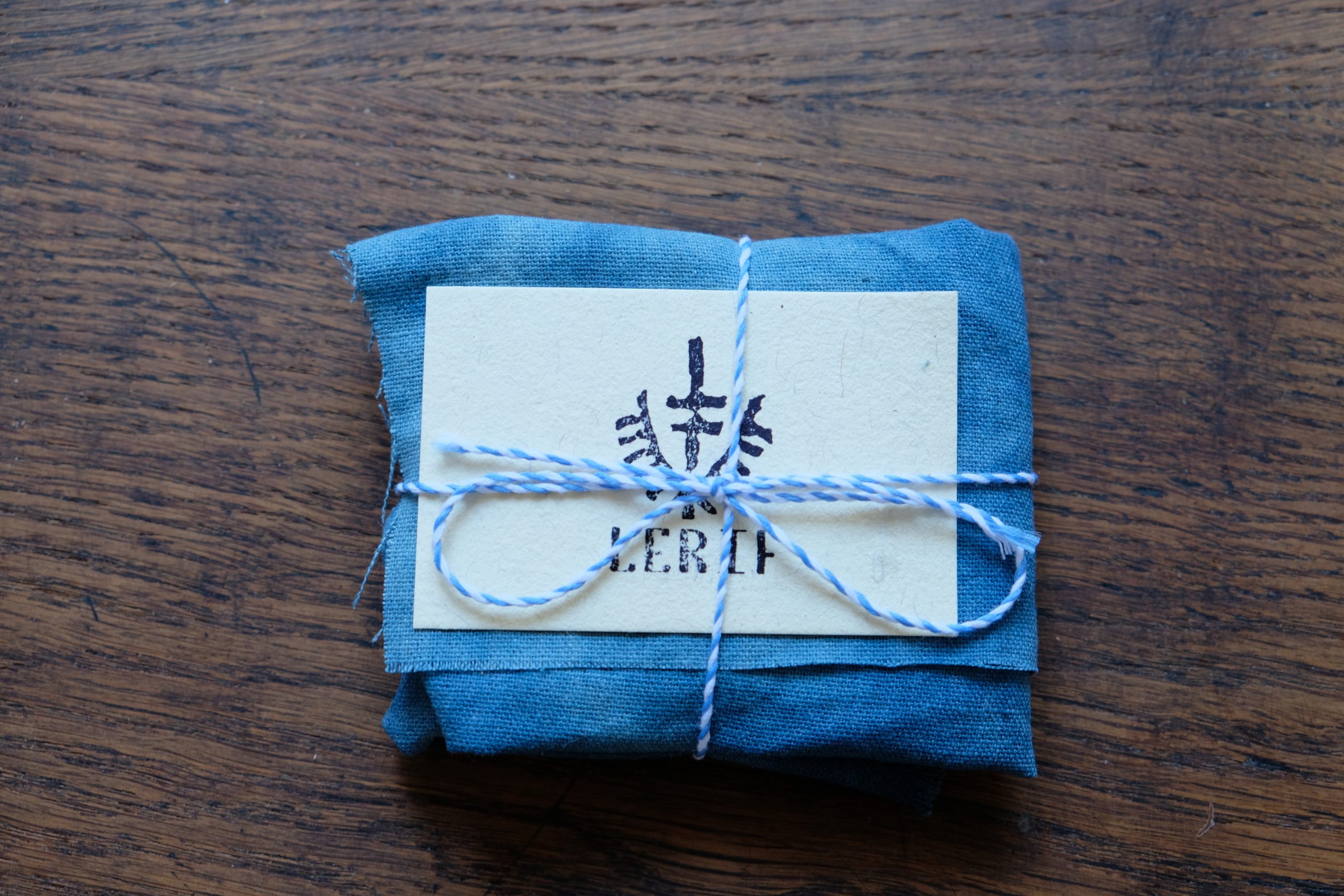 Lerif Designs leather goods packaging wrapped in indigo cloth with blue string and calling card