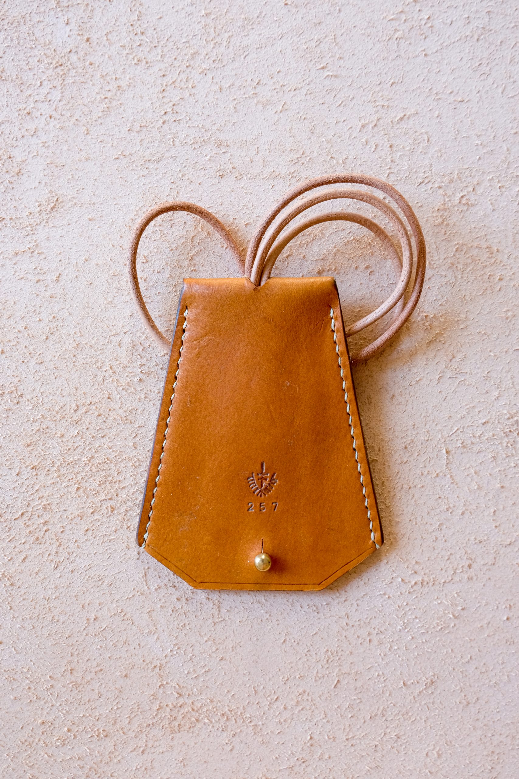 lerif designs leather bell keyholder in turmeric on beige background